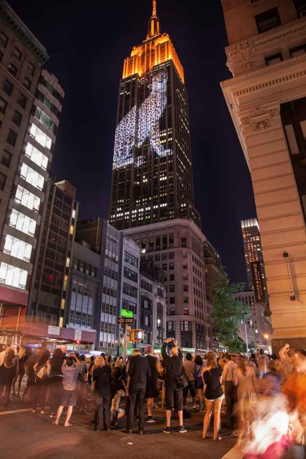 Пешеходы фотографируют проекцию леопарда на Эмпайр Стейт Билдинг в Нью-Йорке